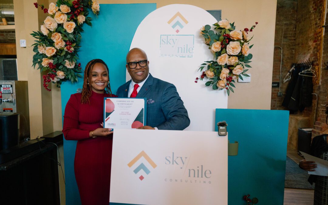 Black woman smiling next to black man holding a proclamation