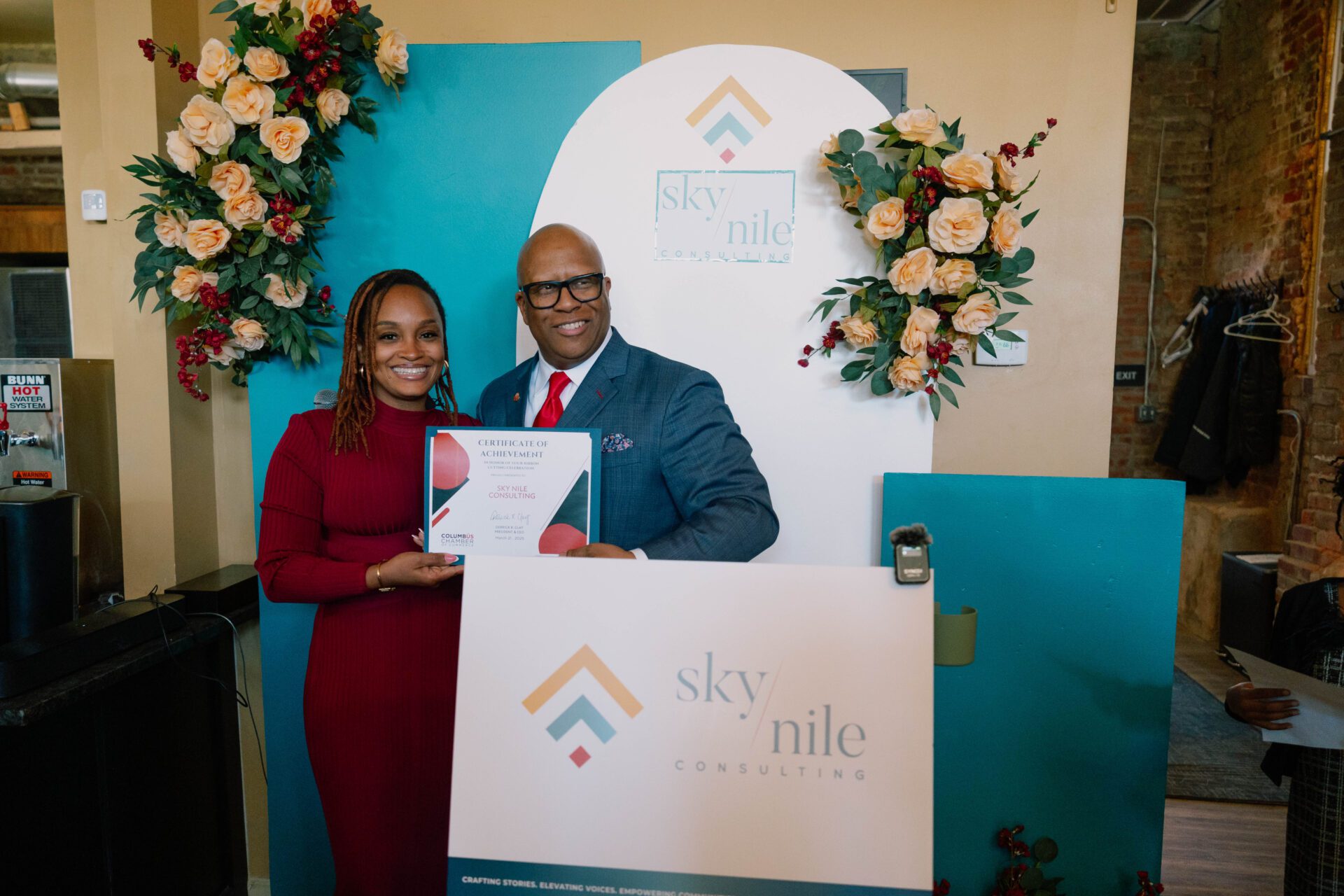 Black woman smiling next to black man holding a proclamation